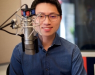 portrait of Hansi Lo Wang ’09 in front of a radio microphone